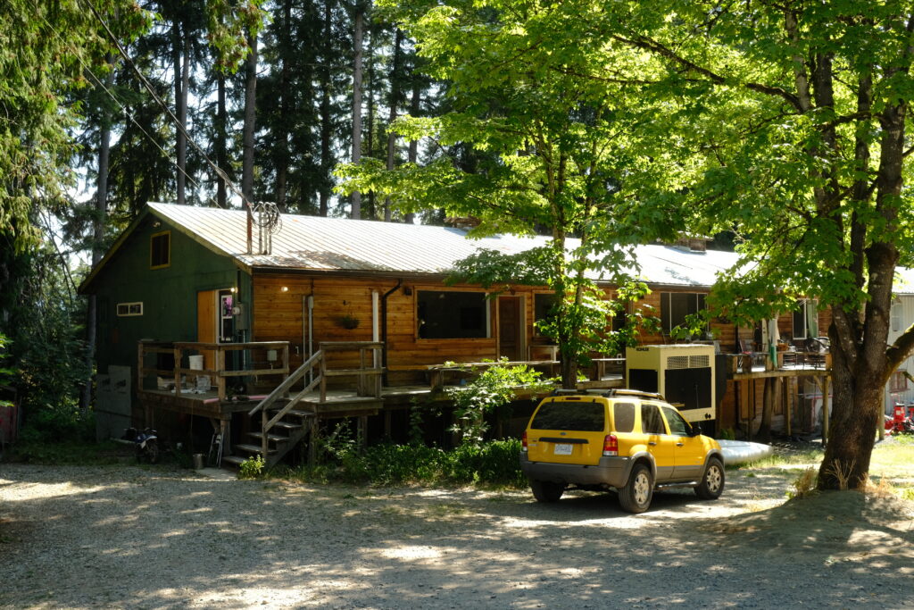 Barn in the forrest with car in front