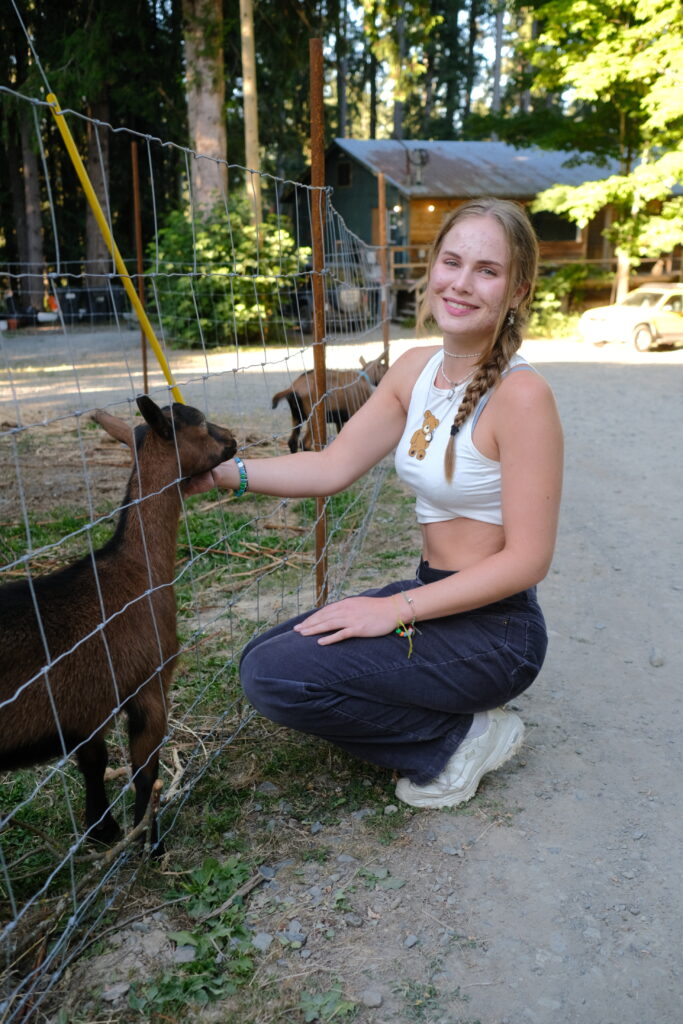 Volunteer Girl cuddling goats